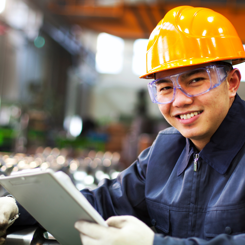 Homem com equipamento de proteção sorrindo e segurado tablet.